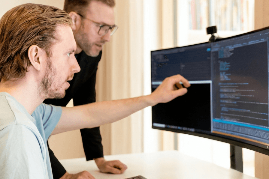 Researchers discussing code on screen